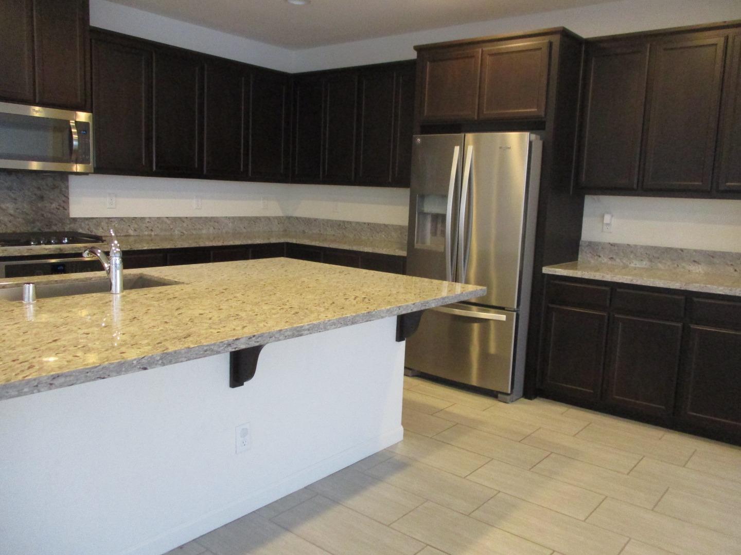 1027 Ruby Way Gilroy, CA 95020 - Photo 2 of 25 a kitchen with stainless steel appliances a refrigerator a stove a sink and cabinets
