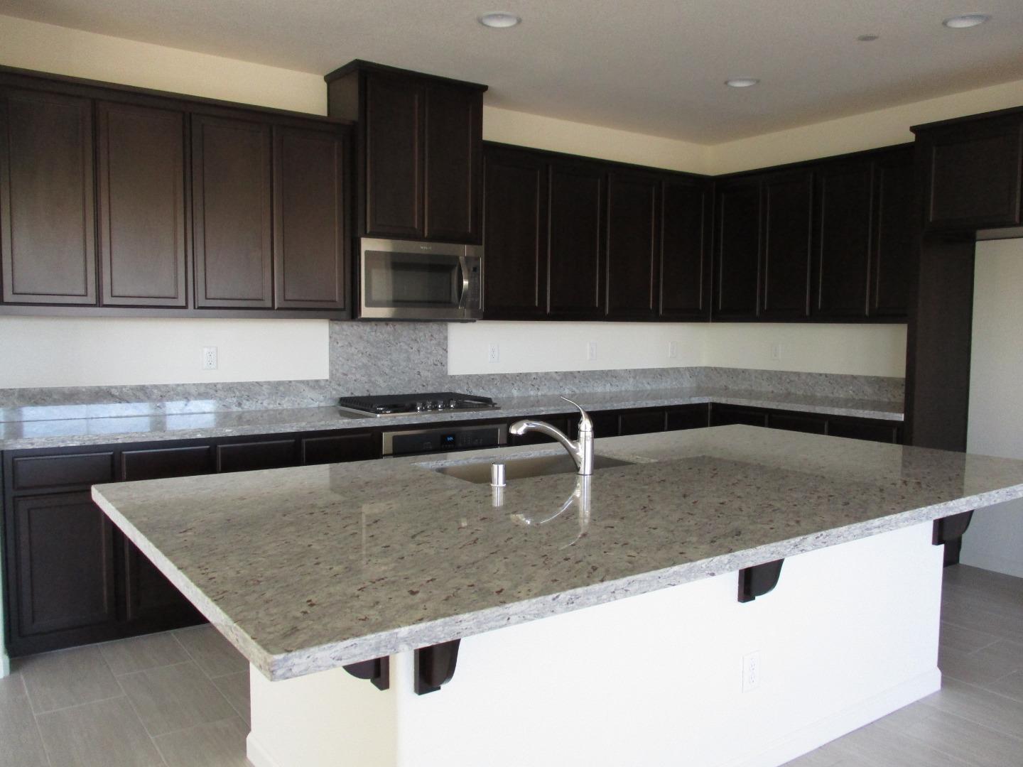 1027 Ruby Way Gilroy, CA 95020 - Photo 4 of 25 a kitchen with a sink a microwave and cabinets