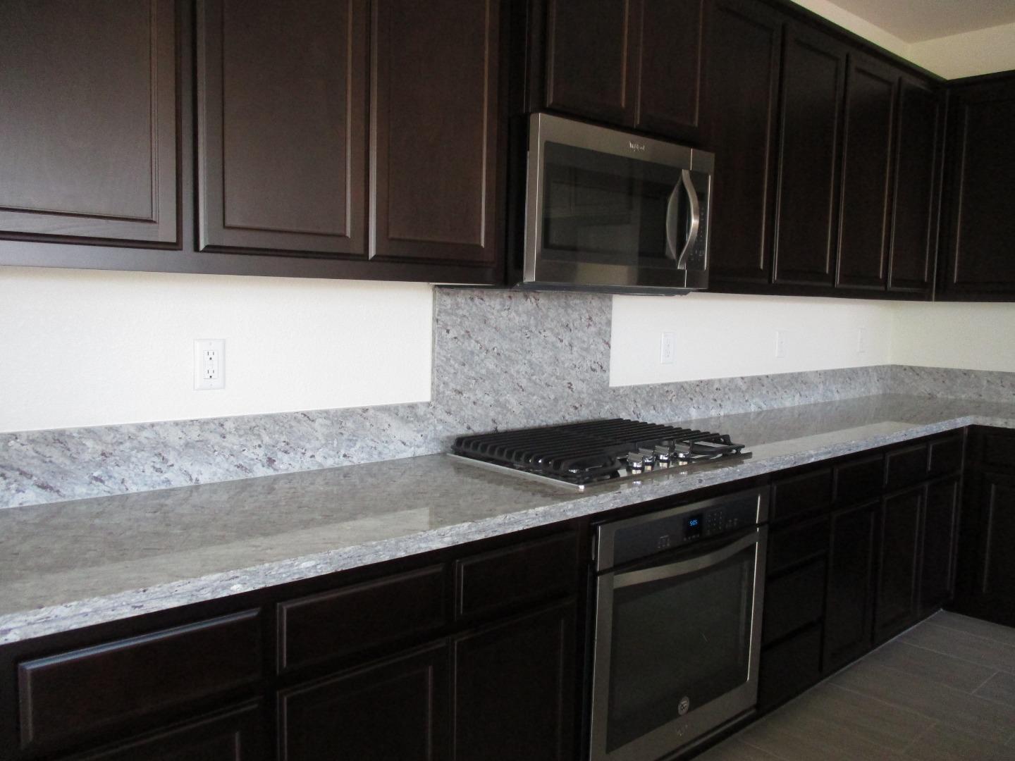 1027 Ruby Way Gilroy, CA 95020 - Photo 5 of 25 a kitchen with granite countertop a cabinets stove and microwave