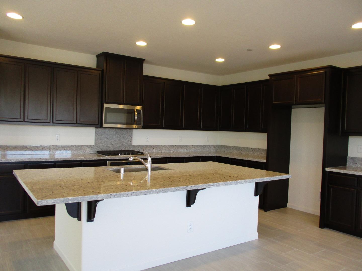 1027 Ruby Way Gilroy, CA 95020 - Photo 7 of 25 a kitchen with kitchen island stainless steel appliances a sink and a refrigerator