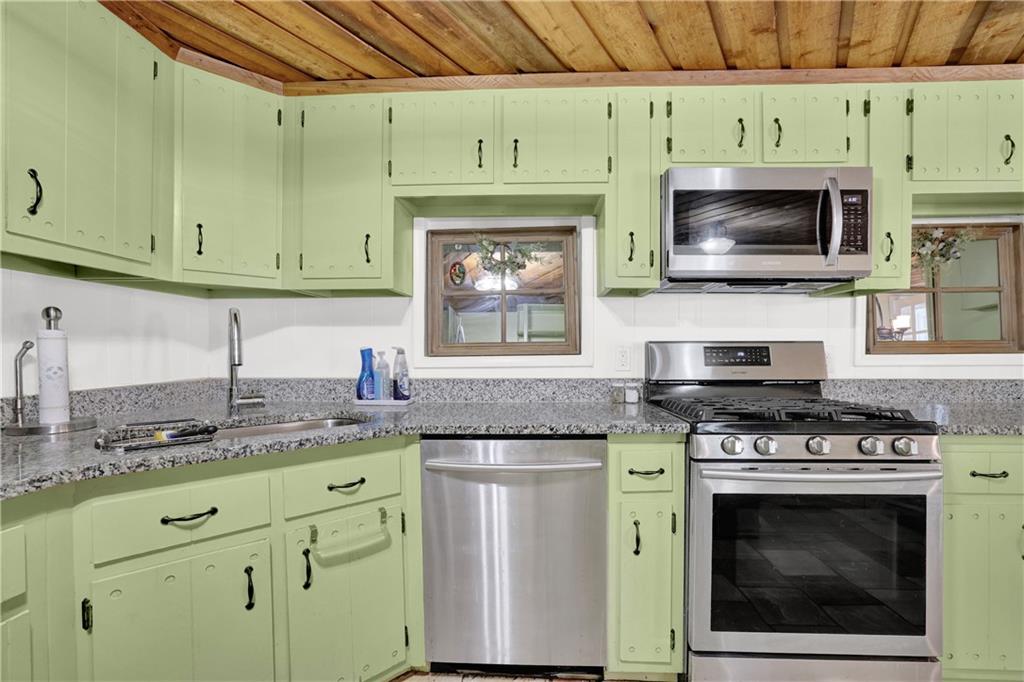 3285 Howell Circle Duluth, GA 30096 - Photo 19 of 33 a kitchen with granite countertop a stove top oven microwave and cabinets