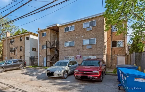 a front view of a house with cars parked on the roadside