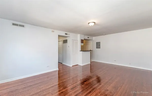 a view of empty room with wooden floor