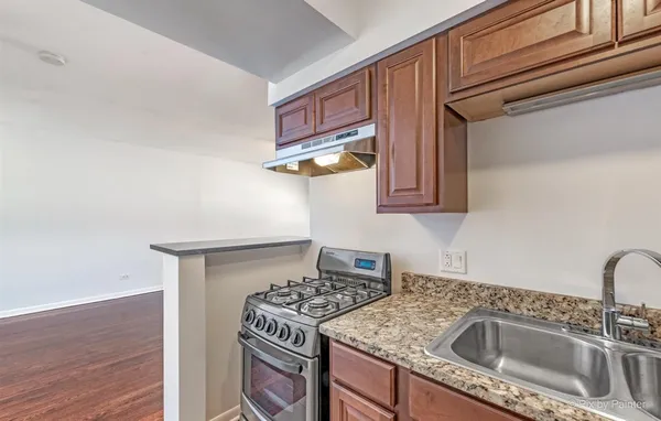 a kitchen with stainless steel appliances granite countertop a sink stove and cabinets