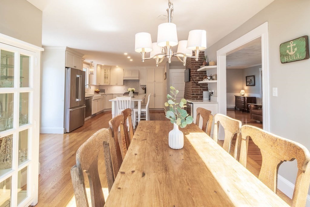 203 Samoset Avenue Hull, MA 02045 - Photo 11 of 39 a view of a dining room and livingroom with furniture wooden floor a chandelier