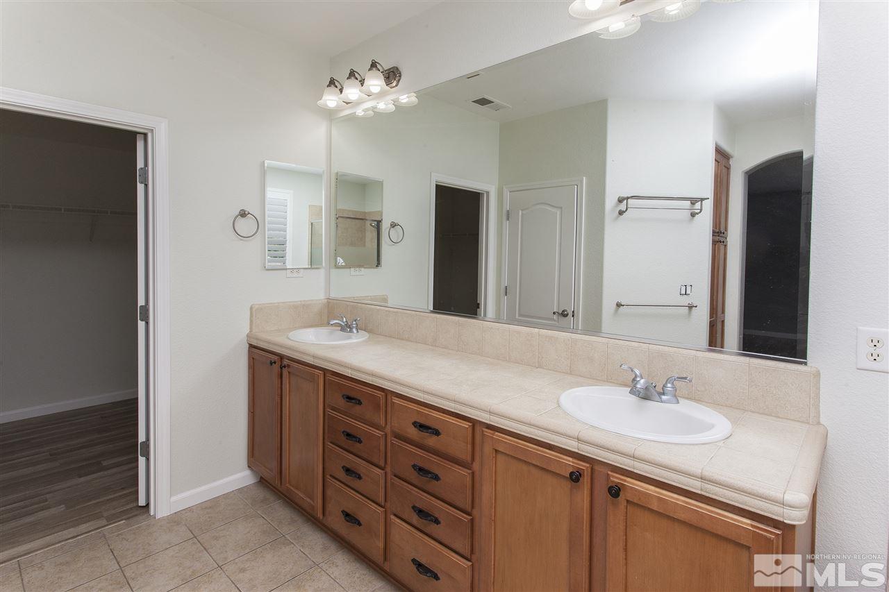 581 Alydar Court Reno, NV 89521 - Photo 16 of 22 a bathroom with a granite countertop sink and a mirror
