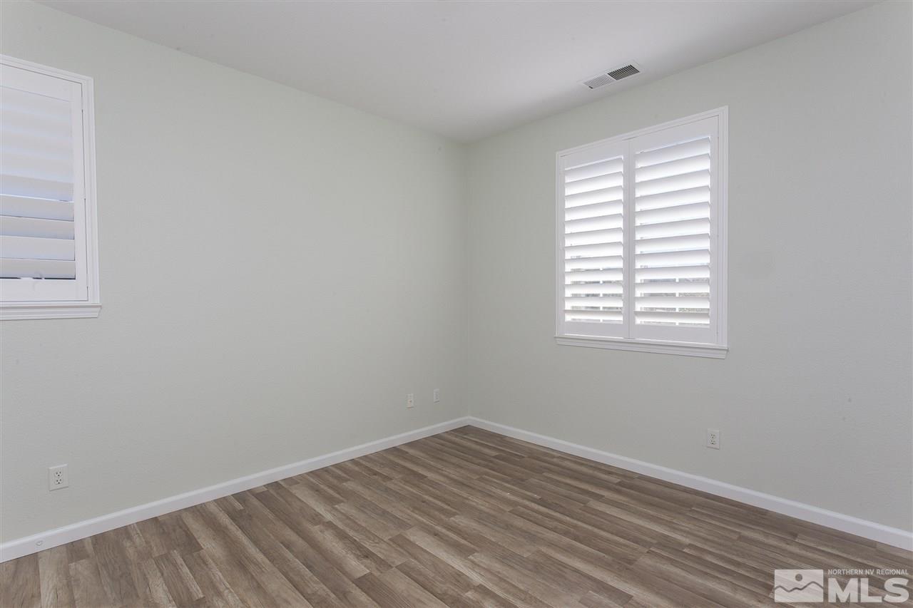 581 Alydar Court Reno, NV 89521 - Photo 19 of 22 an empty room with wooden floor and windows