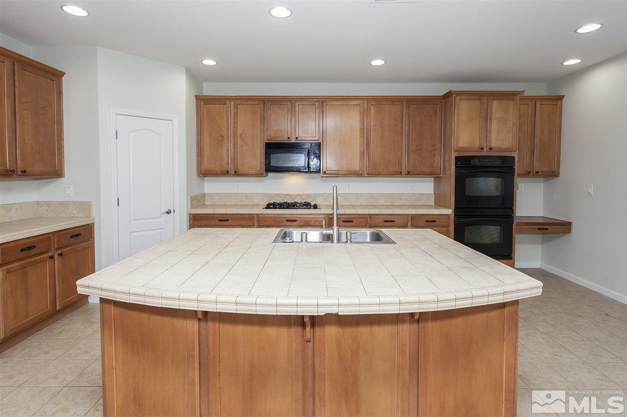 581 Alydar Court Reno, NV 89521 - Photo 6 of 22 a kitchen with kitchen island a sink stainless steel appliances and cabinets