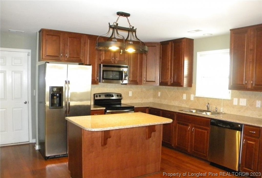 93 Expedition Drive Cameron, NC 28326 - Photo 4 of 19 a kitchen with stainless steel appliances a sink a stove a refrigerator cabinets and a window
