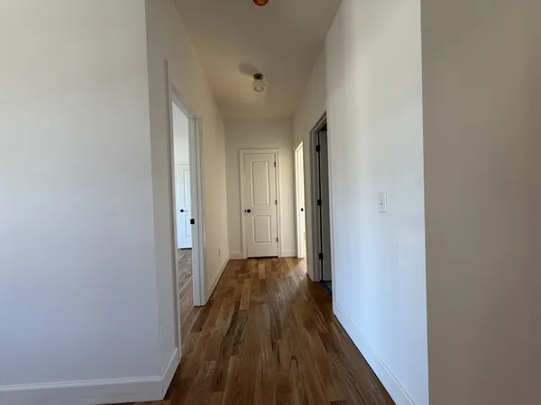 a view of a hallway with wooden floor