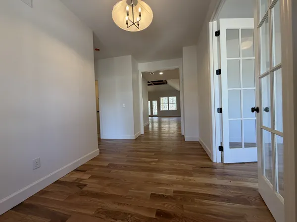 a view of wooden floor and a chandelier fan in a room