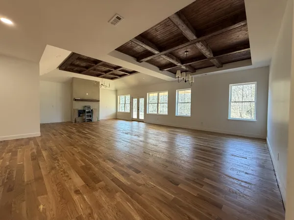 a view of a livingroom with wooden floor and a ceiling fan