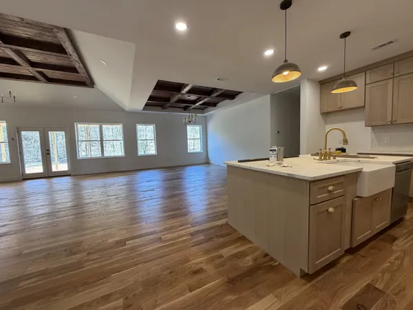a kitchen with a sink and wooden floor