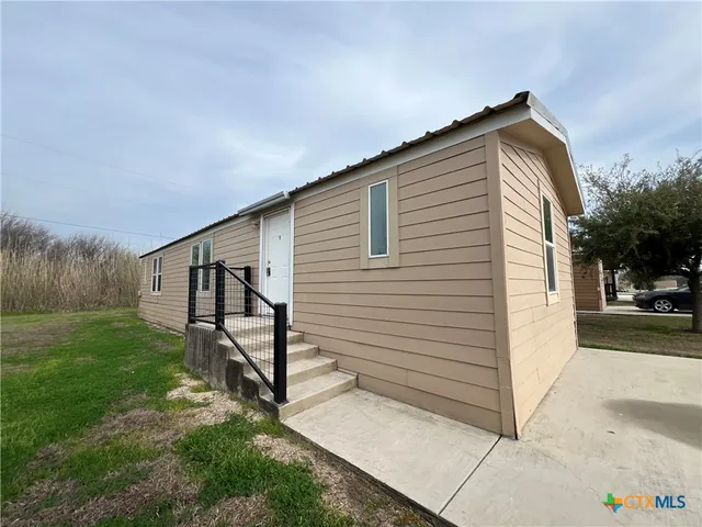 a view of a house with backyard and a tree