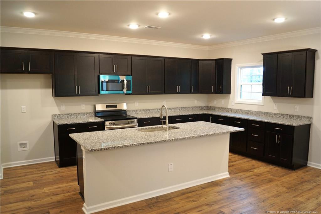 123 Nectar Lane Bunnlevel, NC 28323 - Photo 15 of 36 a kitchen with stainless steel appliances granite countertop a sink a stove top oven a counter space and cabinets