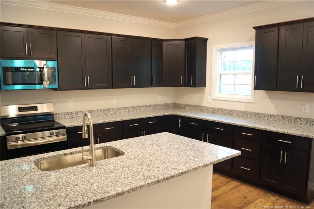 123 Nectar Lane Bunnlevel, NC 28323 - Photo 7 of 36 a kitchen with a sink a microwave and cabinets
