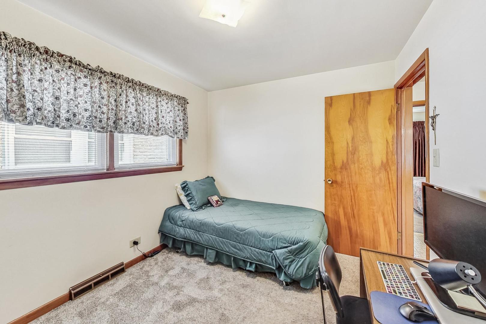 6241 South Rutherford Avenue Chicago, IL 60638 - Photo 17 of 39 a living room with a bed furniture and a flat screen tv