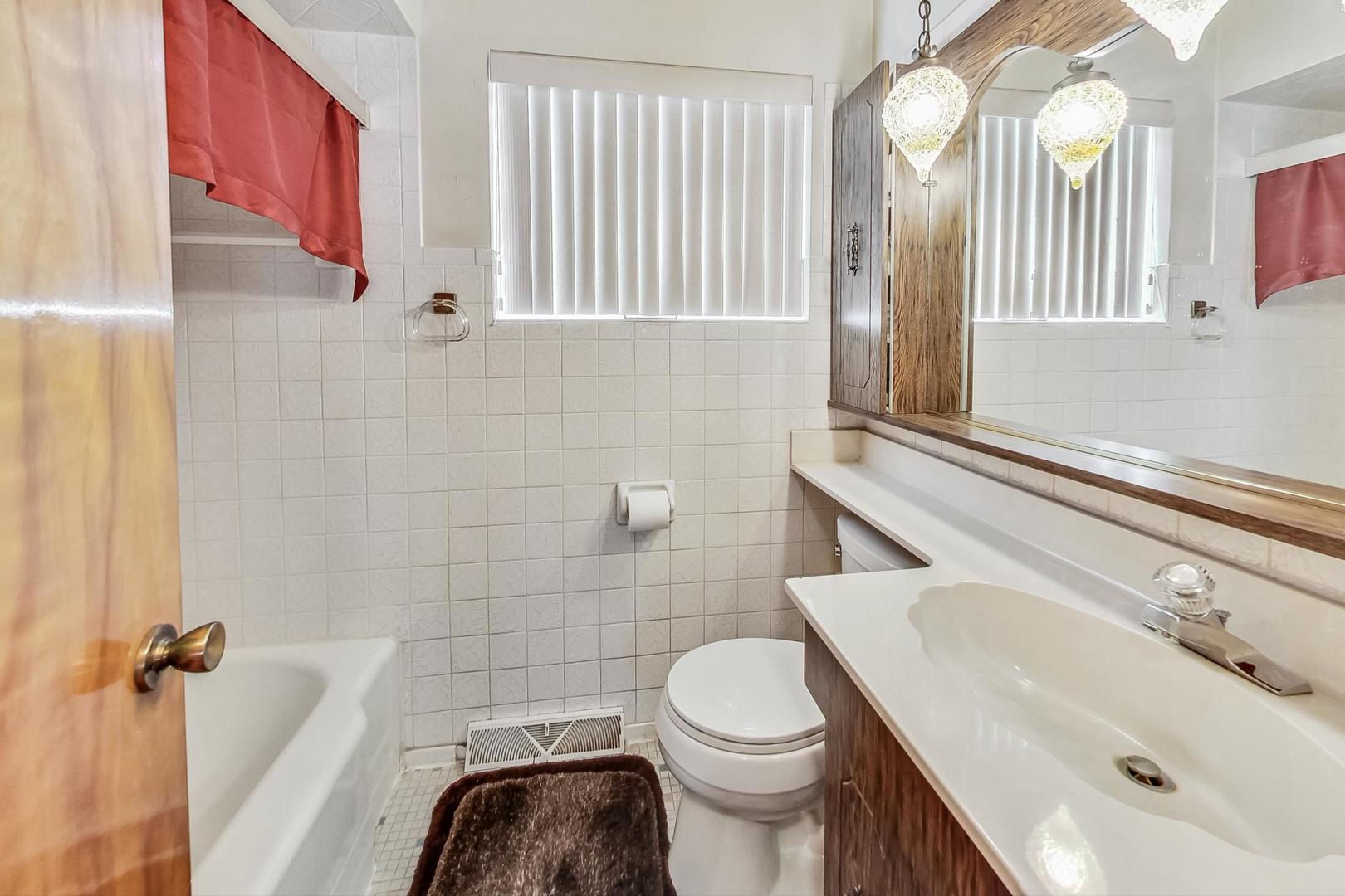 6241 South Rutherford Avenue Chicago, IL 60638 - Photo 18 of 39 a bathroom with a sink and a mirror