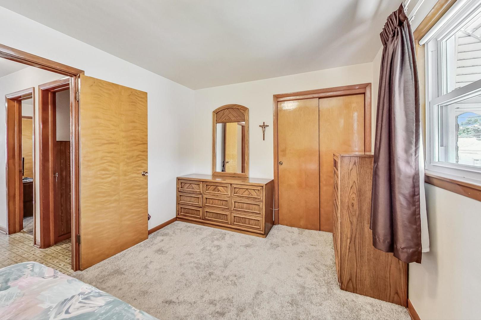 6241 South Rutherford Avenue Chicago, IL 60638 - Photo 21 of 39 a view of a bedroom with wooden floor and windows