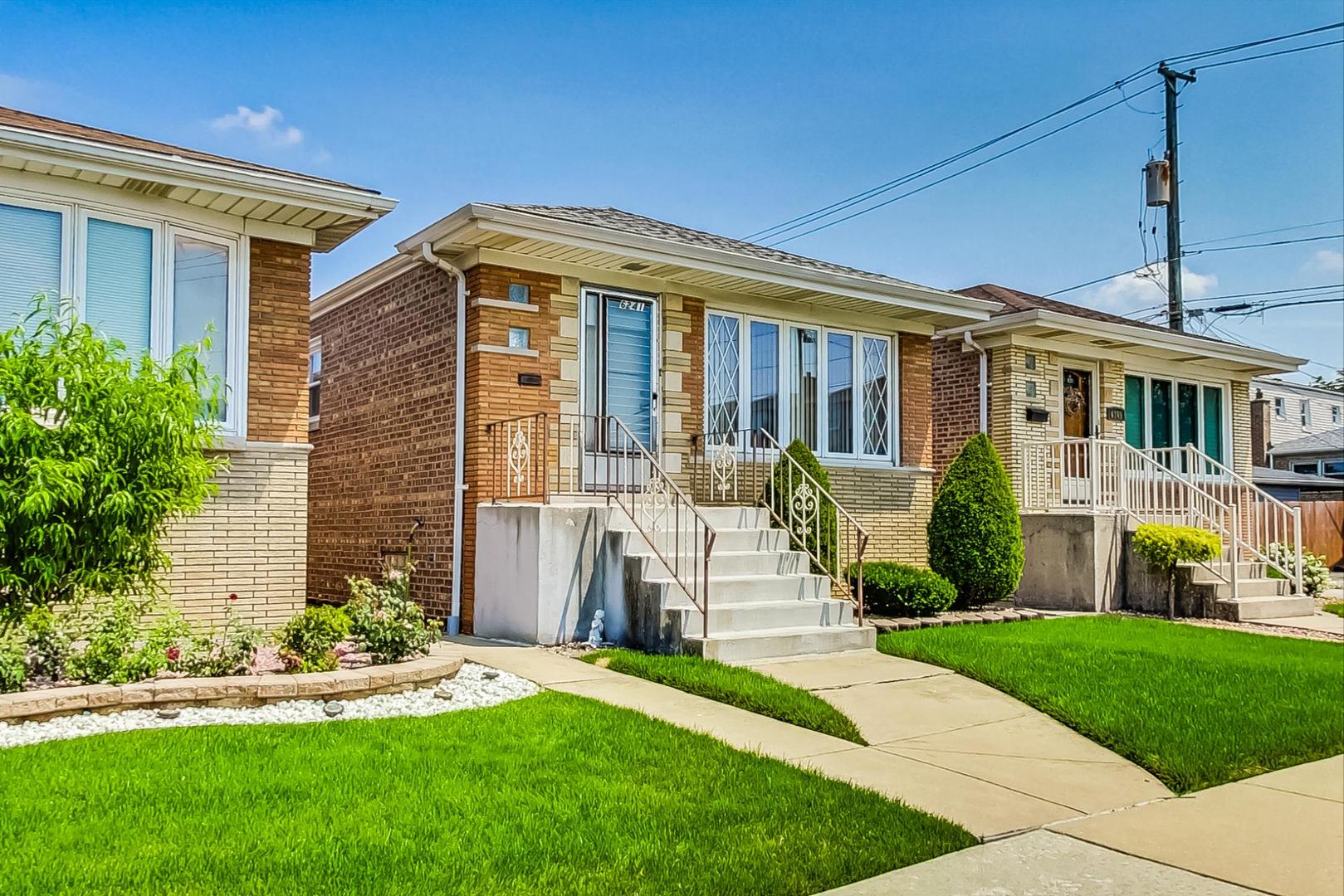 6241 South Rutherford Avenue Chicago, IL 60638 - Photo 3 of 39 a front view of a house with a yard table and chairs