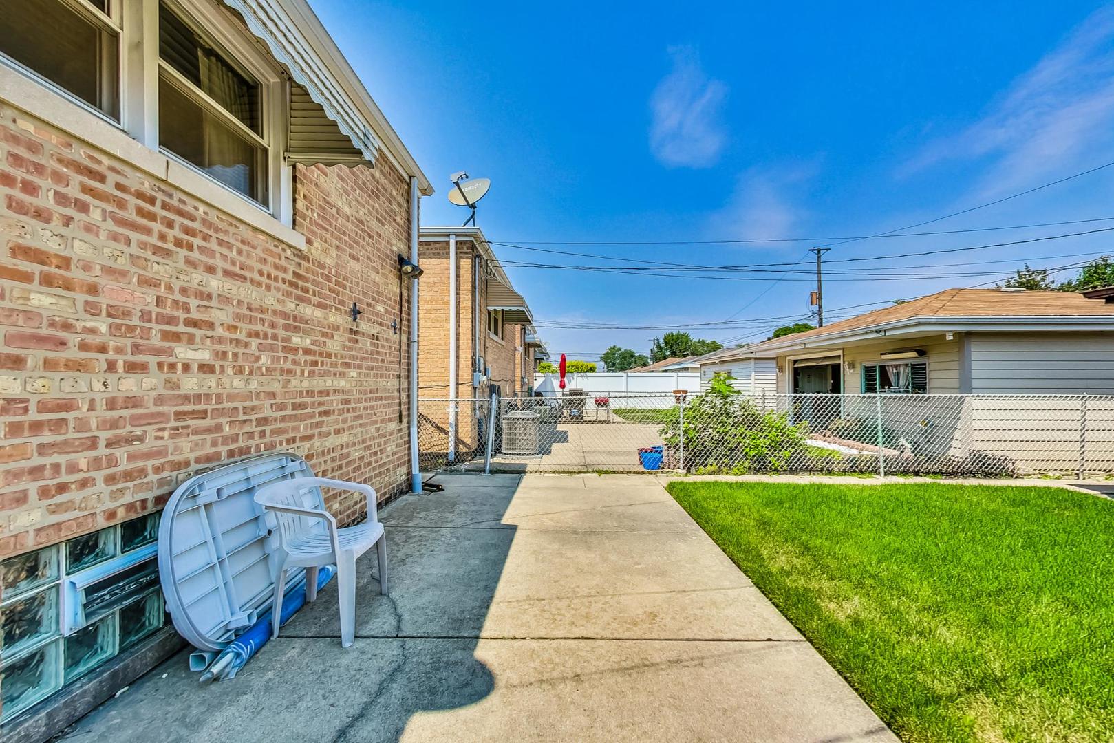 6241 South Rutherford Avenue Chicago, IL 60638 - Photo 31 of 39 a front view of a house with a garden