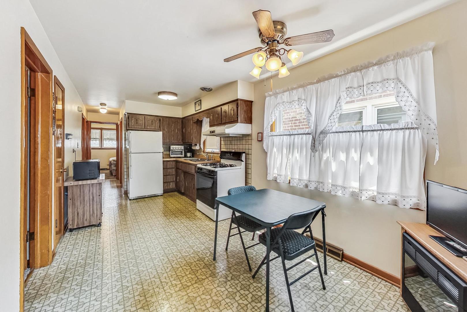 6241 South Rutherford Avenue Chicago, IL 60638 - Photo 7 of 39 a open kitchen with stainless steel appliances granite countertop a refrigerator a stove a sink dishwasher and a dining table with wooden floor