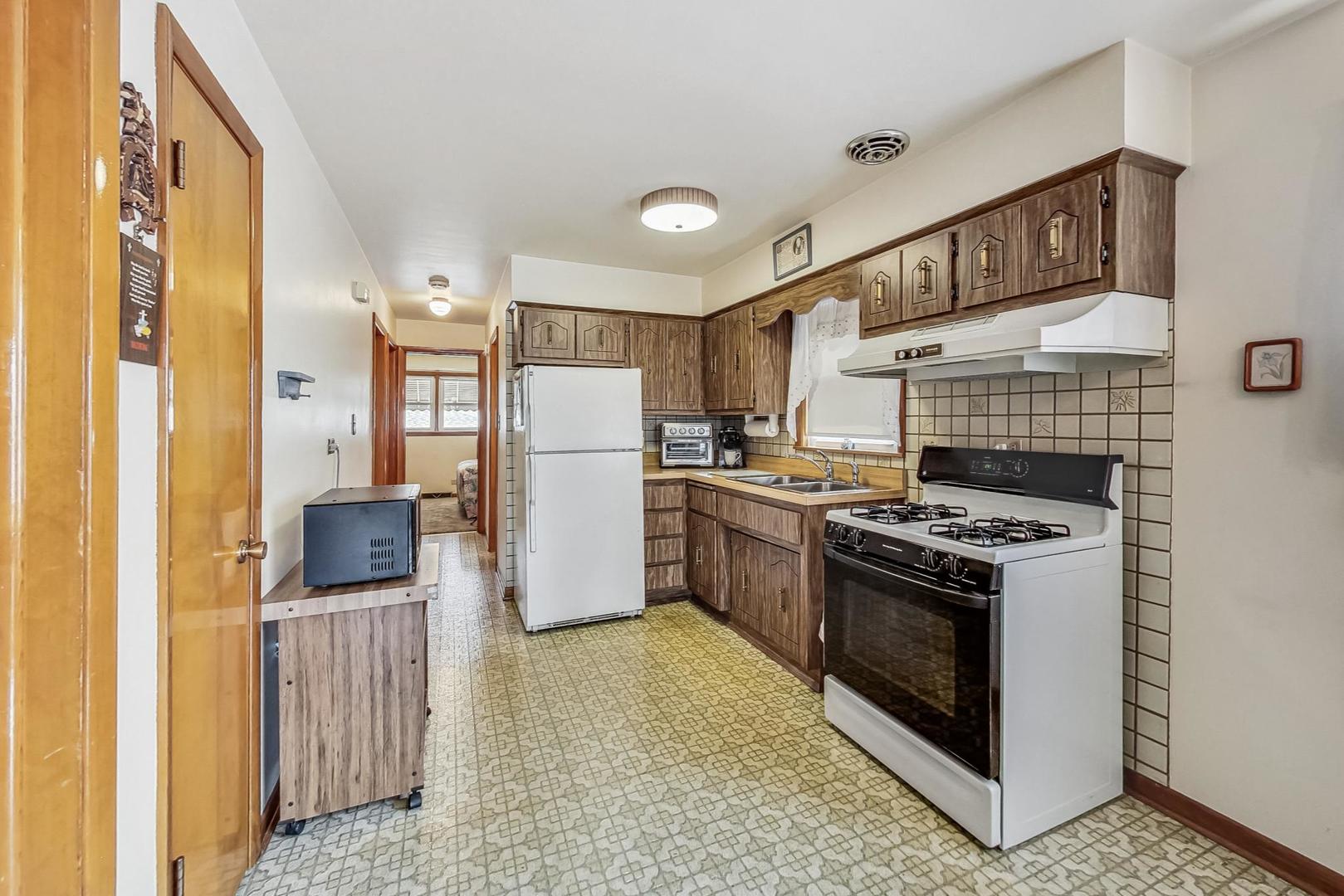 6241 South Rutherford Avenue Chicago, IL 60638 - Photo 8 of 39 a kitchen with a stove a refrigerator and a refrigerator