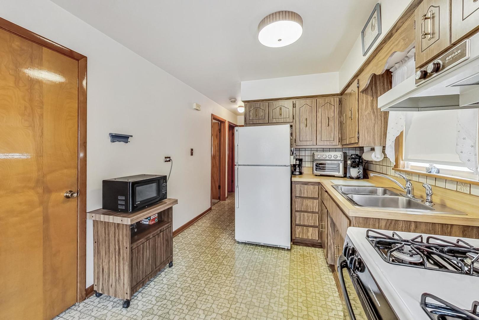 6241 South Rutherford Avenue Chicago, IL 60638 - Photo 10 of 39 a kitchen with a refrigerator a stove and a sink