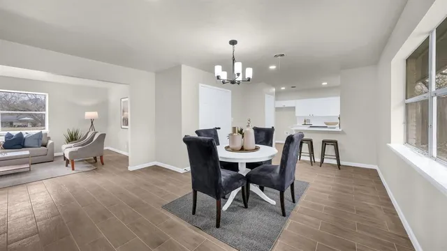 a dining room with furniture a chandelier and wooden floor