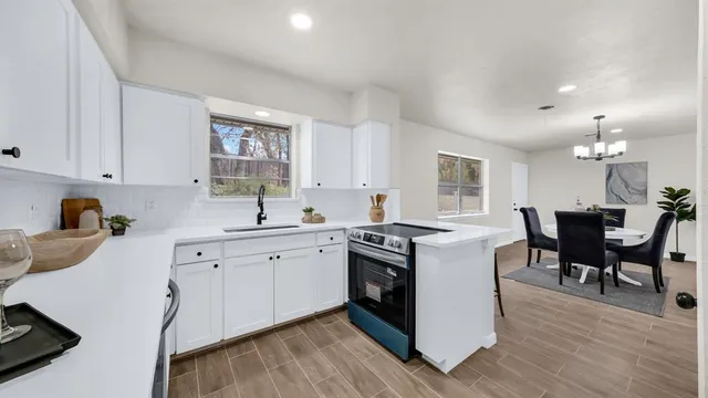 a kitchen with a sink white cabinets and white appliances