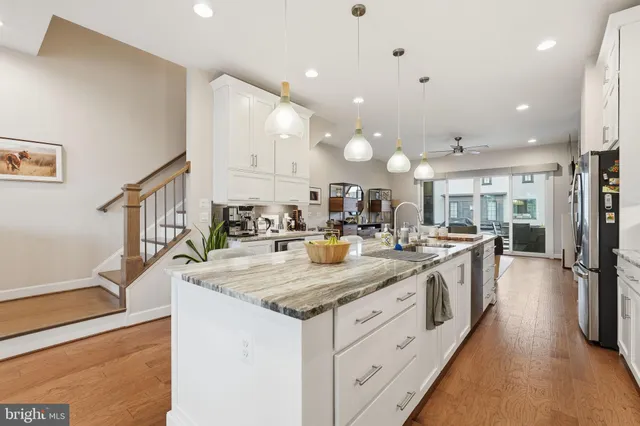 a large kitchen with kitchen island a large counter space a sink and stainless steel appliances