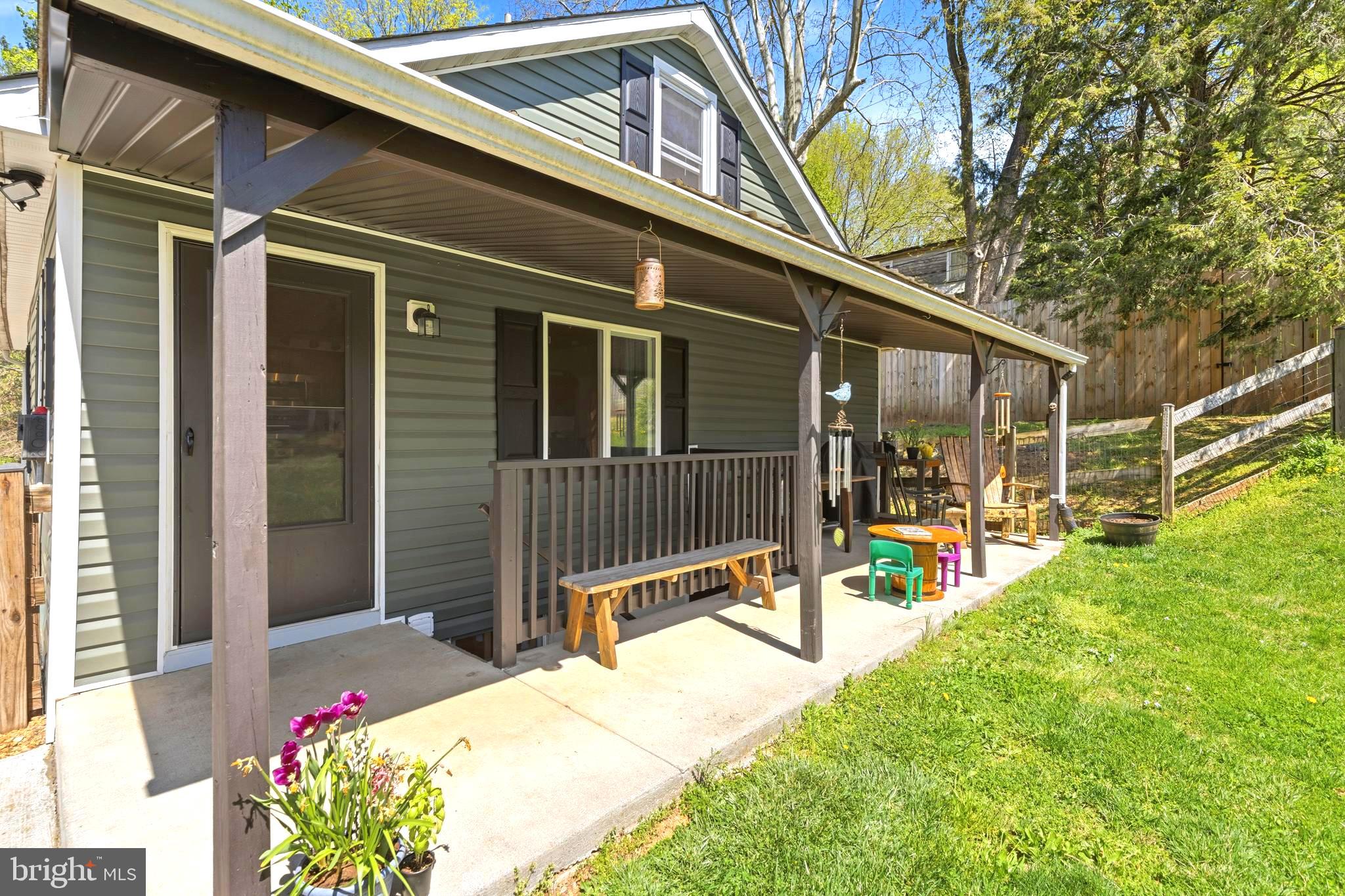 765 Old Manchester Road Westminster, MD 21157 - Photo 26 of 43 a view of a house with a large window and table and chairs under an umbrella