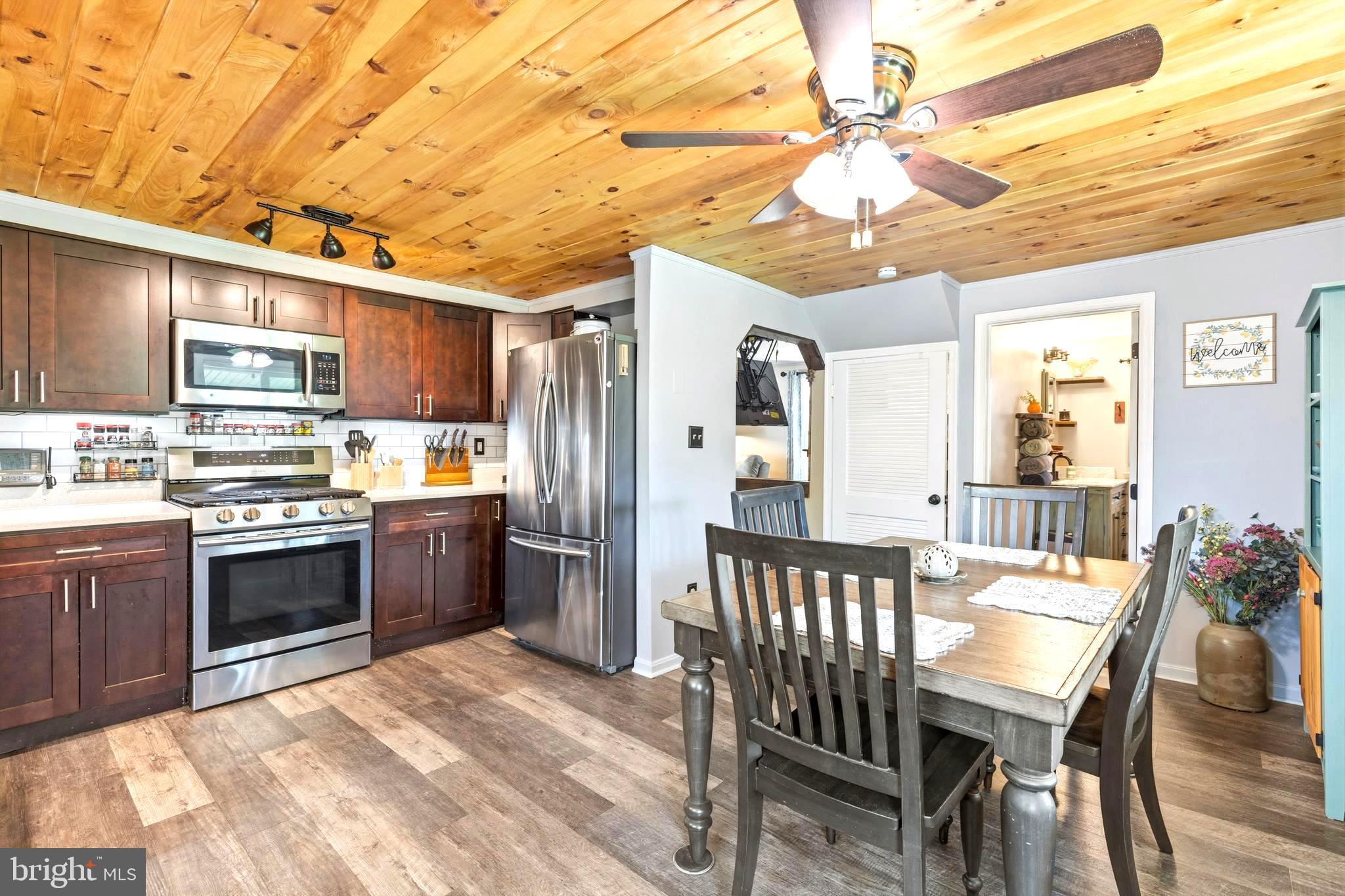 765 Old Manchester Road Westminster, MD 21157 - Photo 9 of 43 a kitchen with stainless steel appliances kitchen island granite countertop a table chairs and a refrigerator