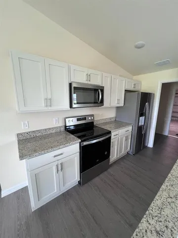 a kitchen with stainless steel appliances kitchen island granite countertop a stove a sink and a microwave