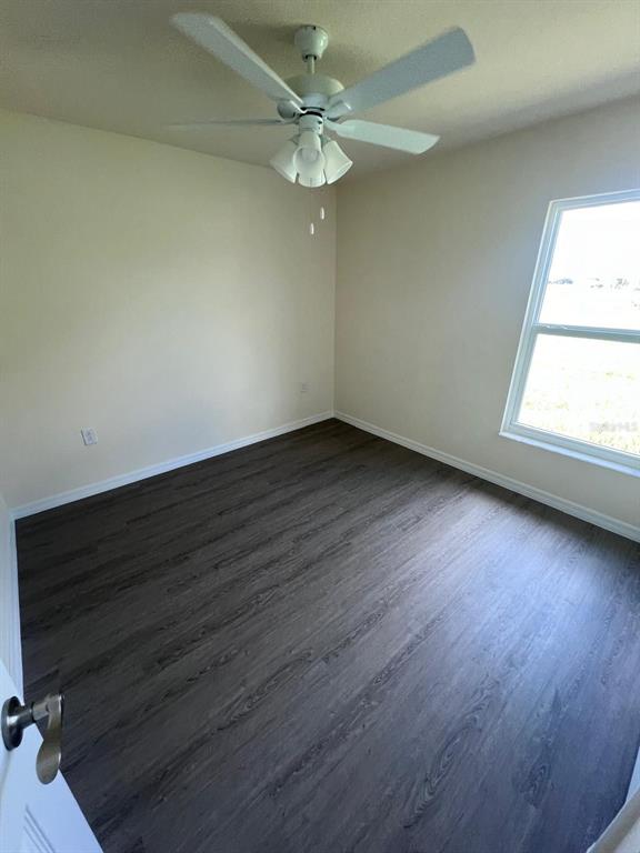 13731 Southwest 89 Circle Ocala, FL 34473 - Photo 13 of 34 an empty room with wooden floor and windows