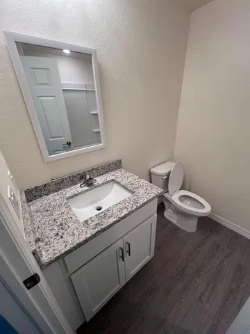 a bathroom with a granite countertop sink and a mirror