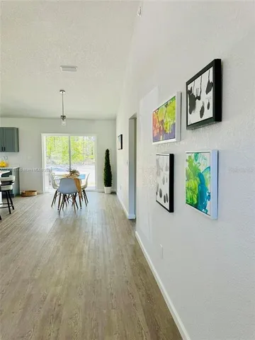 a dining room with furniture a floor to ceiling window and potted plants