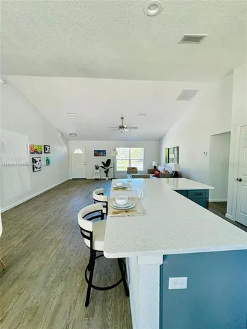 a room with kitchen island a wooden floor and a sink