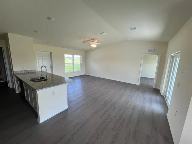 a kitchen with granite countertop a sink and a refrigerator