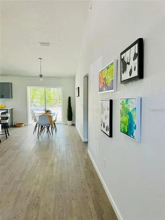 a dining room with furniture a floor to ceiling window and potted plants