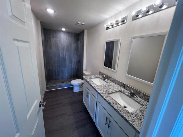 a bathroom with double vanity and a mirror