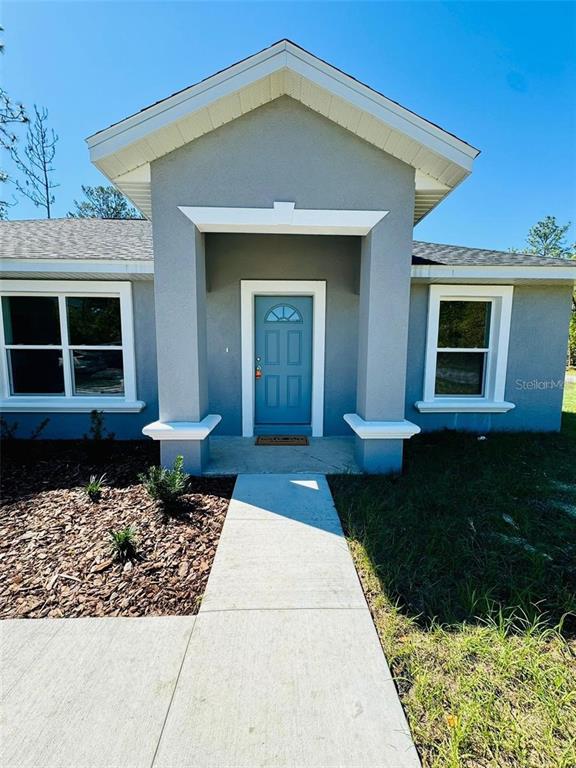 13731 Southwest 89 Circle Ocala, FL 34473 - Photo 6 of 24 a front view of a house with a yard