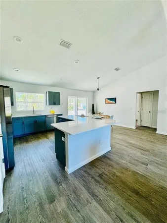 a large kitchen with kitchen island wooden floors and stainless steel appliances