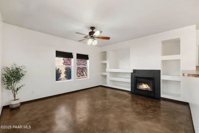 a view of an empty room with a fireplace and a window