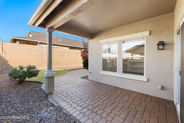 a front view of a house with a yard and potted plants