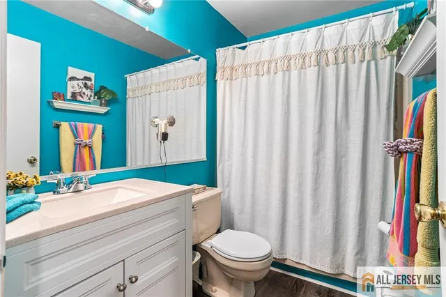 a bathroom with a sink a toilet and shower curtain
