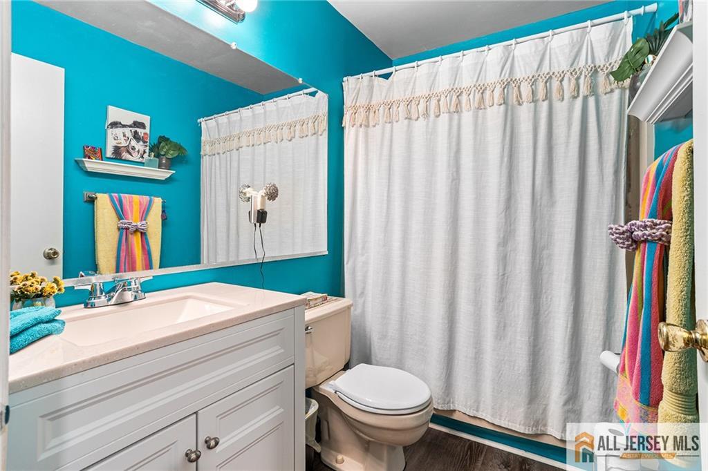 1511 Pebble Place, Unit 1511 Sayreville, NJ 08859 - Photo 14 of 26 a bathroom with a sink a toilet and shower curtain