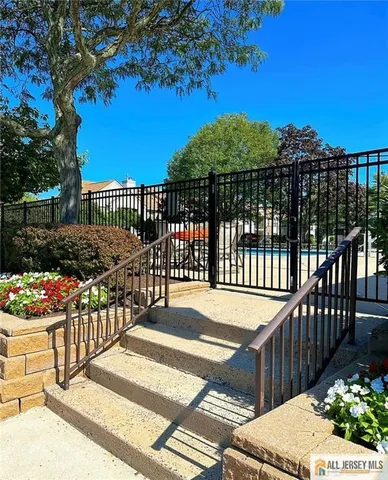 a view of a swimming pool with a bench and trees