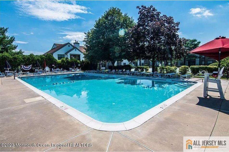 1511 Pebble Place, Unit 1511 Sayreville, NJ 08859 - Photo 22 of 26 a view of a swimming pool with a bench and trees