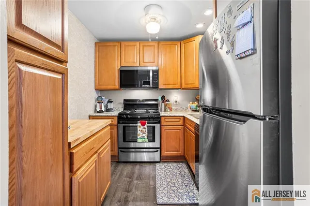 a kitchen with stainless steel appliances a refrigerator stove and microwave
